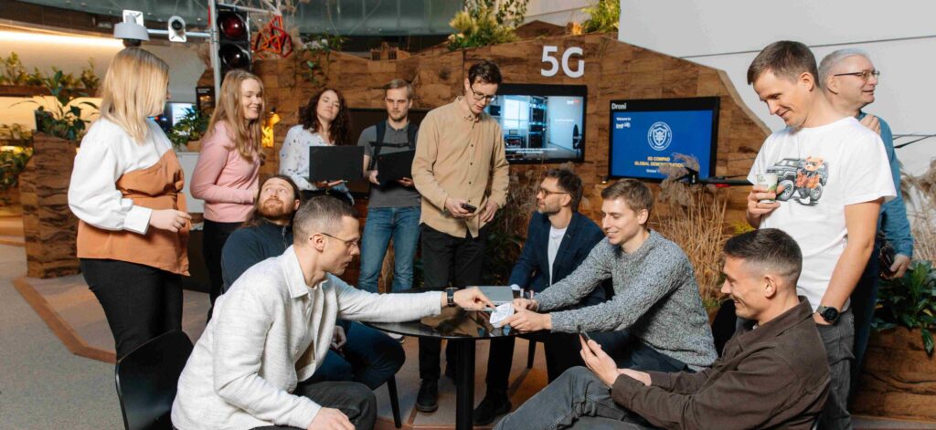 LMT IoT team members gathered around a table discussing IoT solutions.