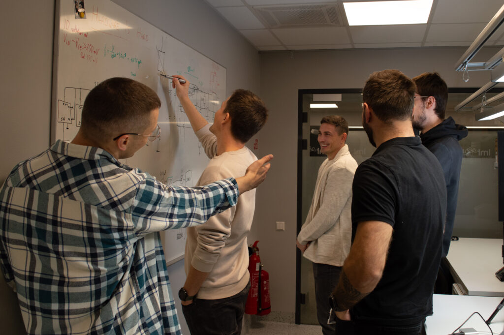 LMT IoT team discussing electronic circuit diagrams during IoT solution development.