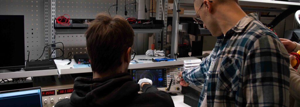 Engineers testing electronic equipment during a hands-on IoT lab session.
