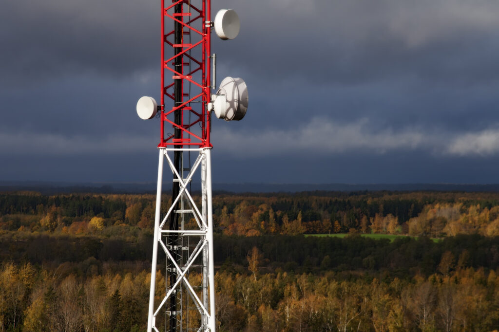 Mobile network tower providing cellular connectivity across a forested landscape.