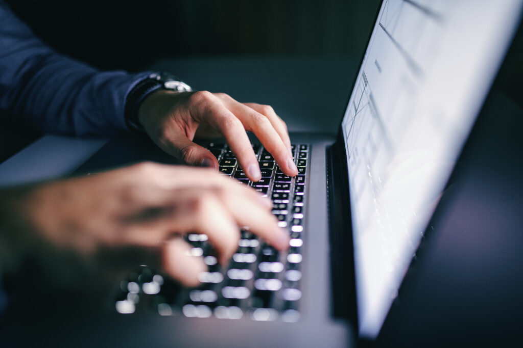 Hands typing on a laptop, representing secure digital processes and enterprise standards.