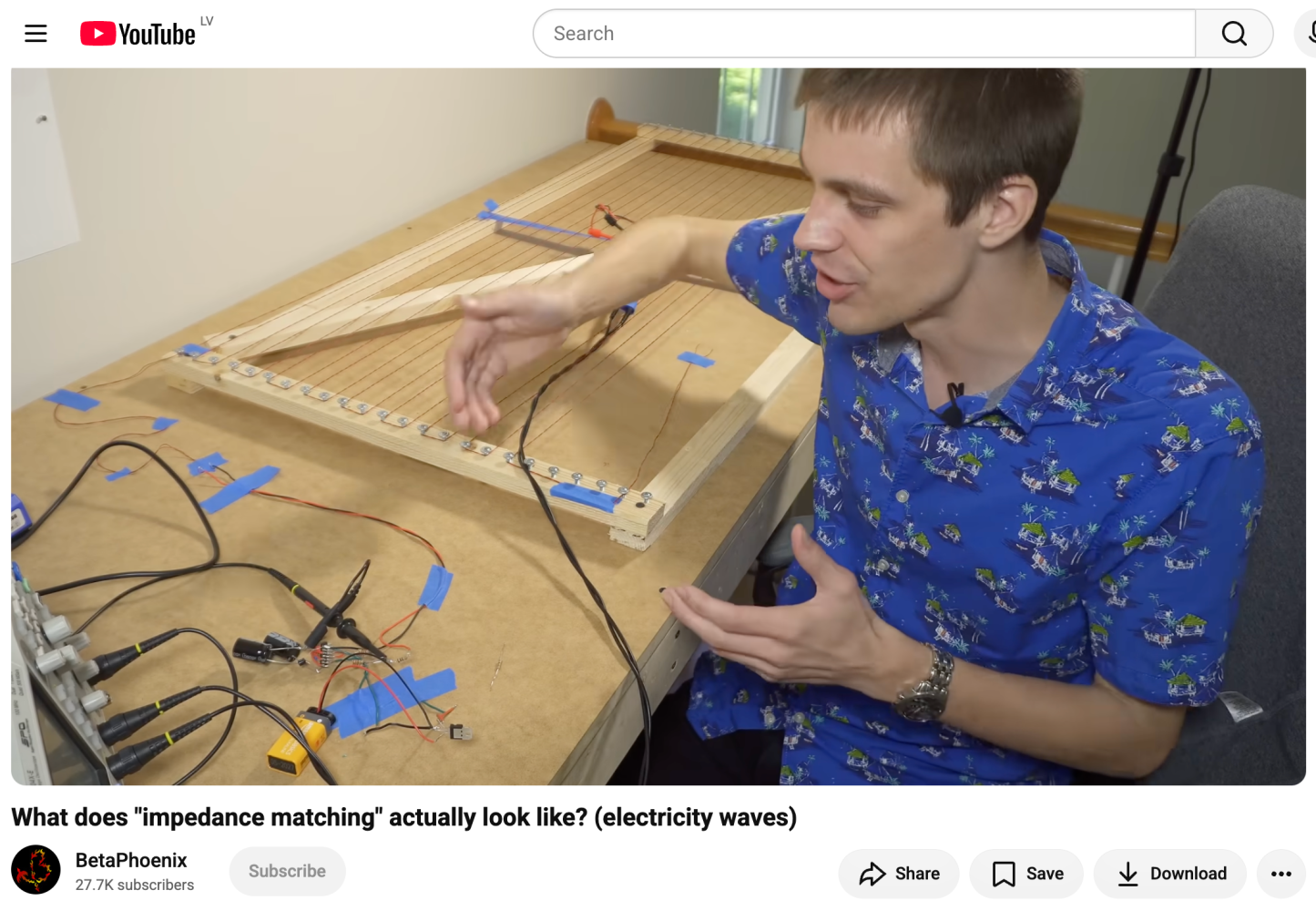 YouTube video titled What does impedance matching actually look like? electricity waves by BetaPhoenix showing a man gesturing toward a large wooden wave demonstration board with parallel strings on a workbench